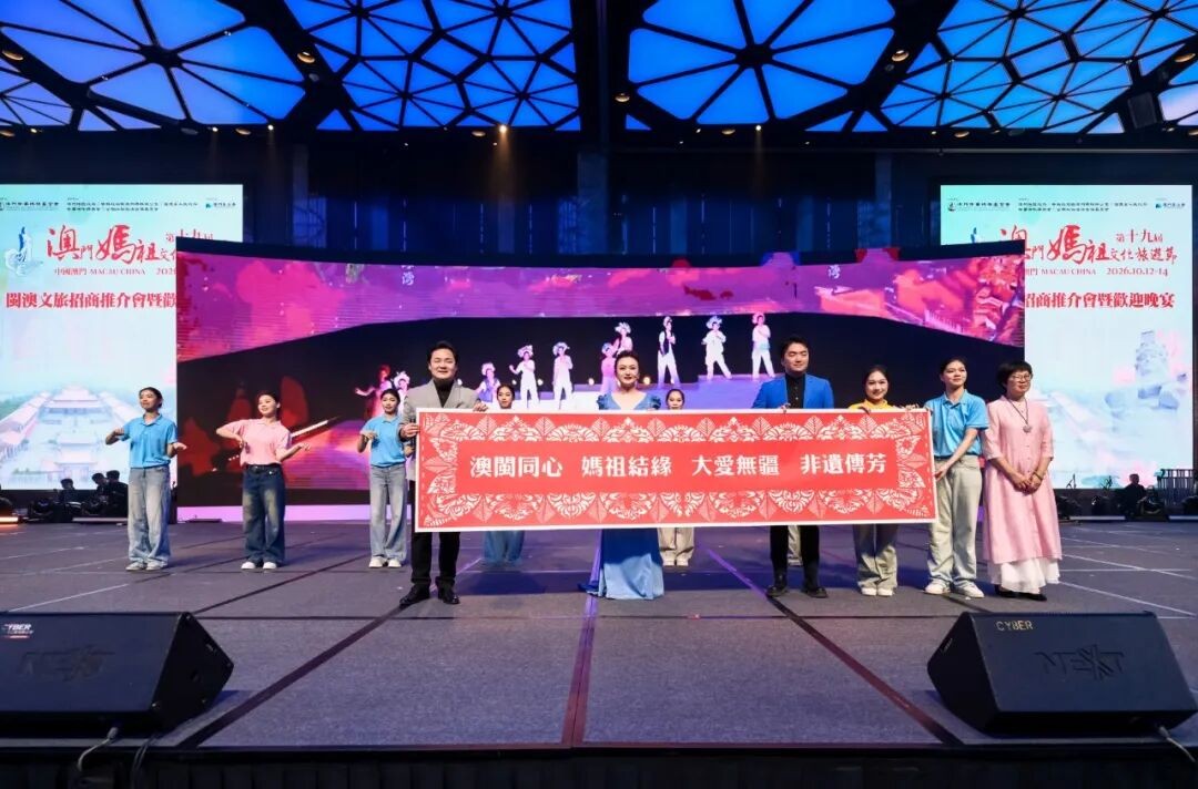Performers on stage hold a banner at the event.